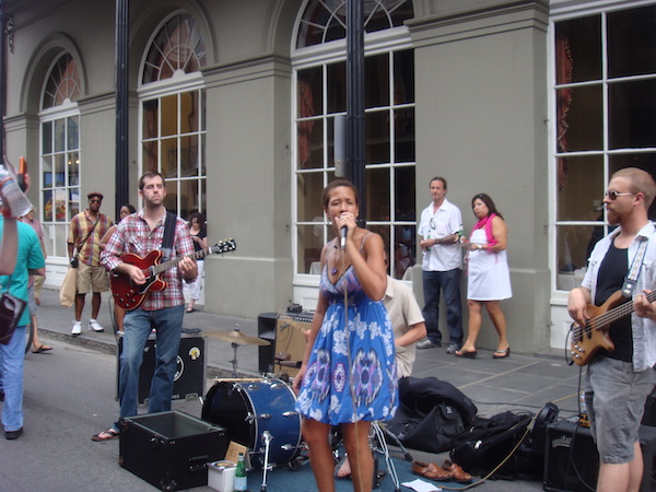 A group of Jazz musicians performing on the street in front of a building