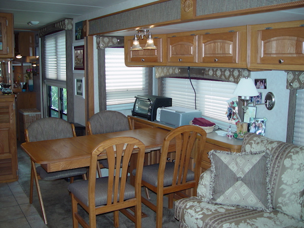 RV dining table and chairs in light oak with cabinets above window