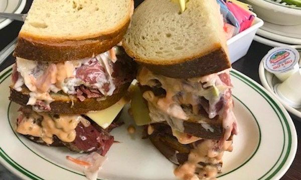 A huge overstuffed hot pastrami sandwich on rye with coleslaw and Russian Dressing