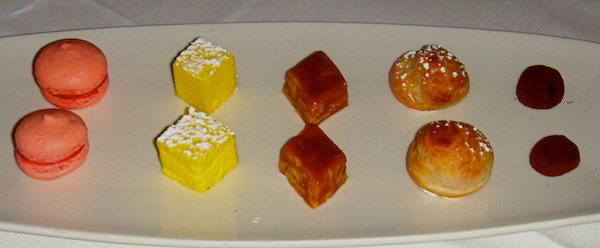 A rectangular white plate topped with pairs of sweets