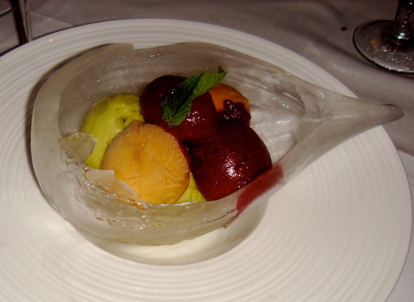 A teardrop shaped ice bowl filled with various colored sorbet balls
