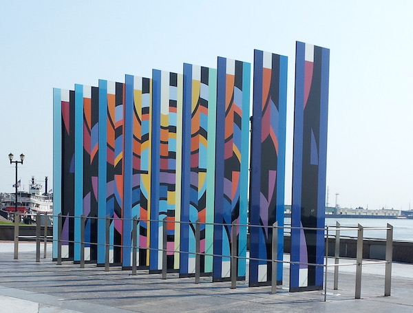 Multicolored painted columns forming a memorial wall.