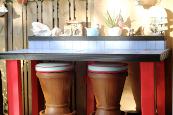 A tiled counter with two rattan bar stools