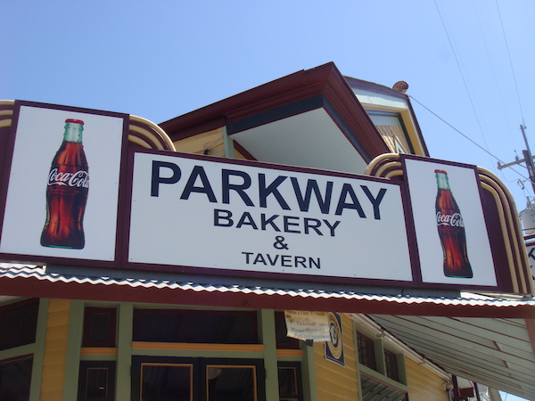 The exterior of a restaurant with a large sign that reads Parkway Bakery and Tavern.
