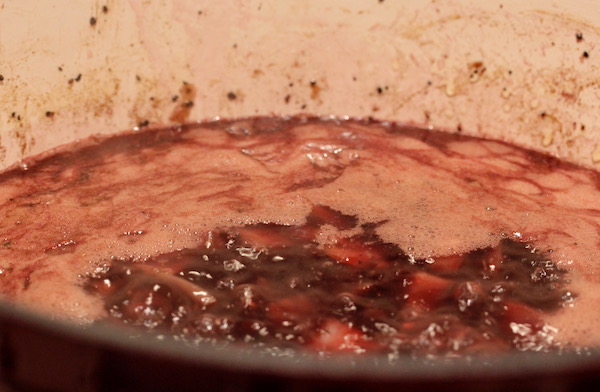 A deep red enameled Dutch oven with wine, Port and Chile stock for the Red Chile Short Rib Tacos.