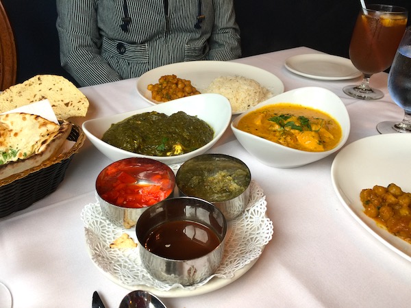 A variety of Indian dishes on a white tablecloth