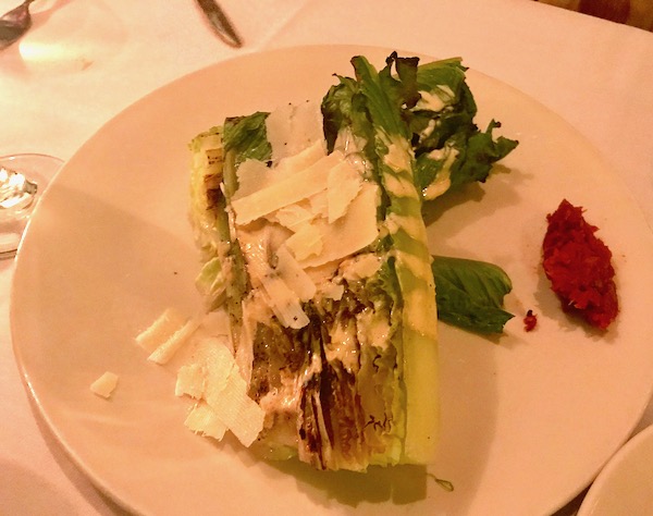 Grilled Romain with anchovies and shaved Parmesan on an ivory plate