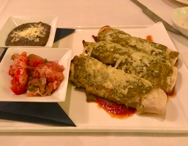Enchiladas and condiments on a white square plate