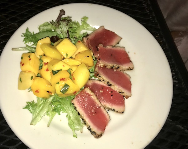 Seared Ahi Tuna and Lemon Ginger Gastrique with Spicy Mango Salad on a white plate