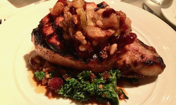Pork Chop with Sorghum Apple Chutney on a white plate
