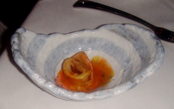 Ceramic oyster shell shaped dish with a tortellini and red sauce