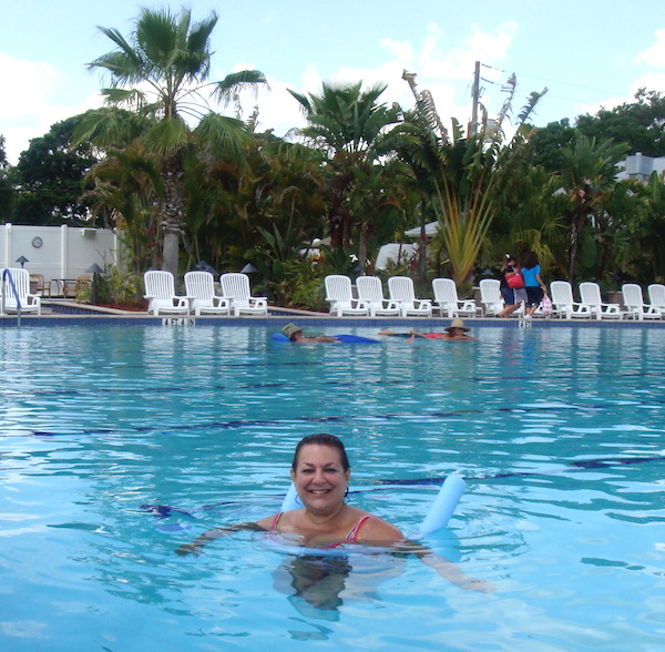 Woman floating in large swimming pool