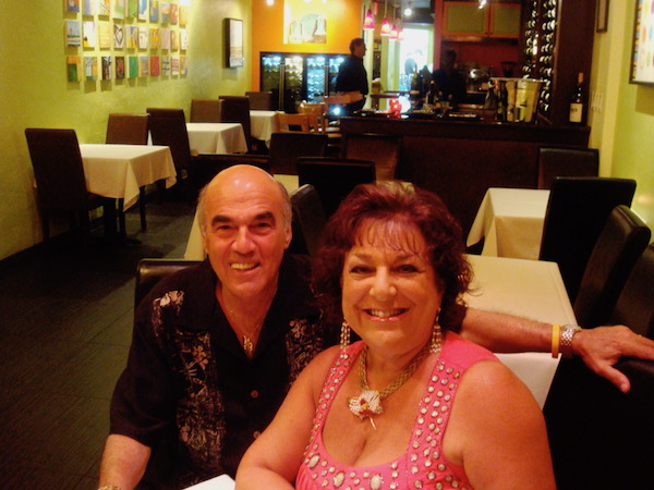 Man in black shirt and woman in pink blouse in a restaurant