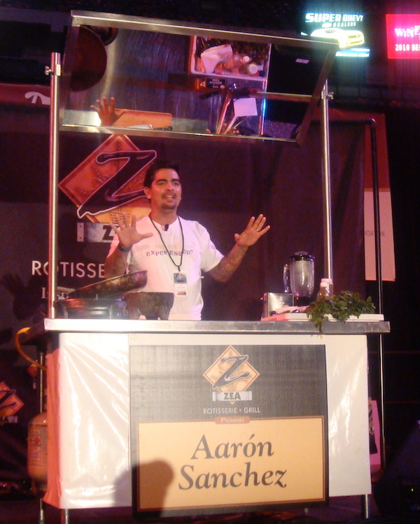 A man behind a podium doing a cooking demo