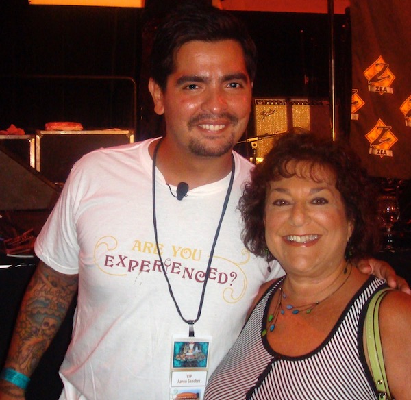 A sun tanned man with dark hair and a mustache in a white t-shirt and a suntanned woman with dark curly hair in a black and white striped top
