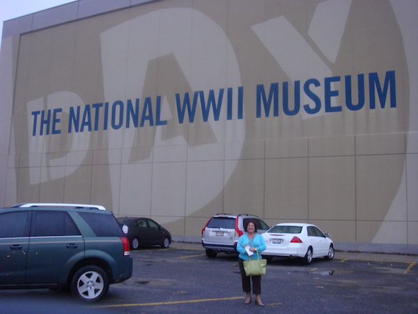 Parking lot outside of the National World WarII Museum with Sandy in turquoise sweater standing in front