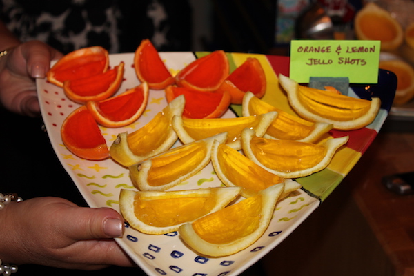 A triangular painted ceramic platter topped with jello filled orange and lemon wedges