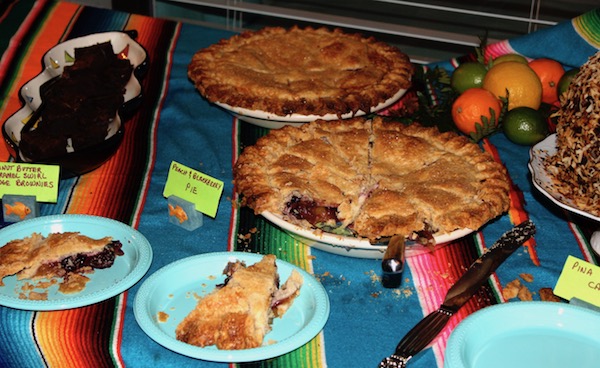 Assorted pies, cakes and brownies sitting on a Mexican blanket