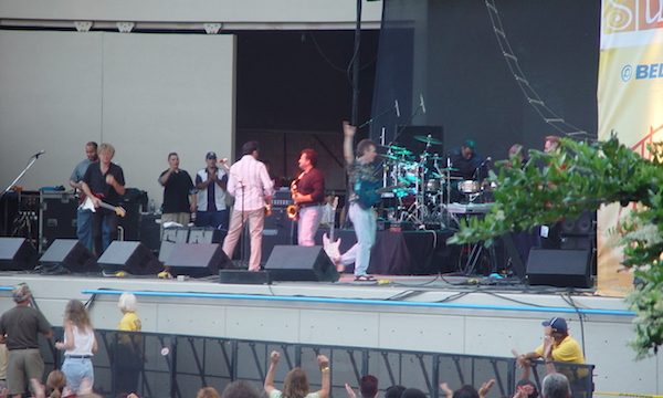 A stage with musicians and fans watching below