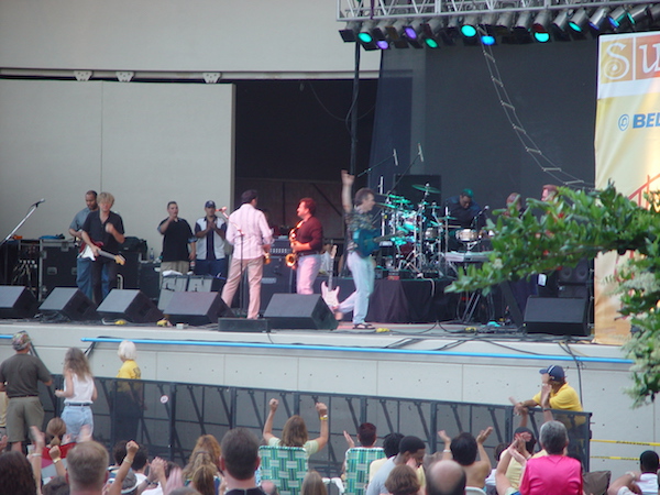 A stage with musicians and fans watching below