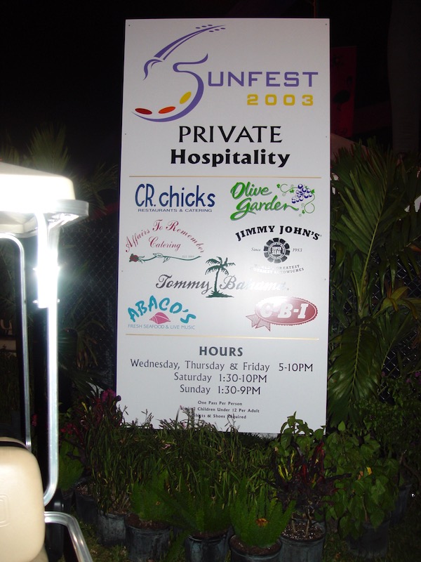 A white sign with list of event sponsors