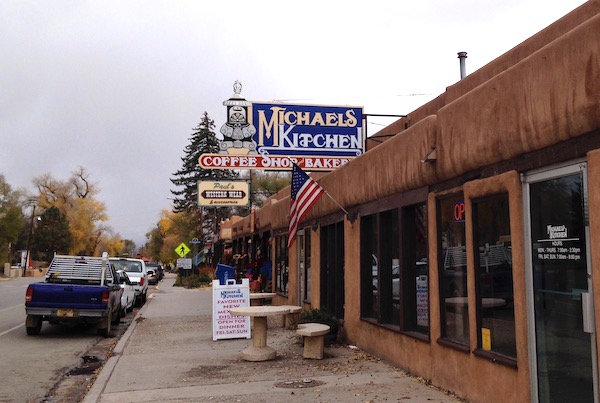 A strip mall with a restaurant that has a blue sign and says Michael's Kitchen