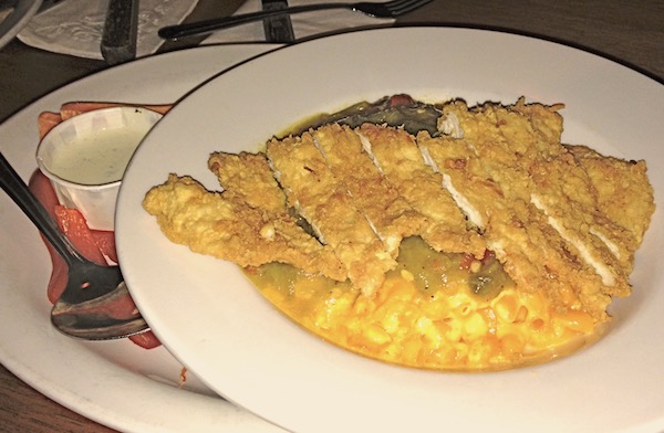 A large ivory plate with slices of fried chicken breast and macaroni and cheese.