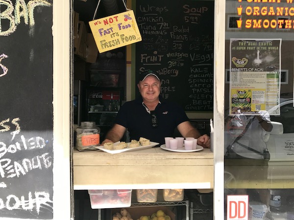 A man in the window of a take out restaurant