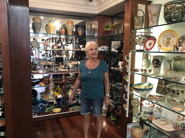 A woman standing in a gallery in front of glass cases