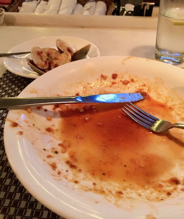 A white plate with just a little reddish juice left on it.
