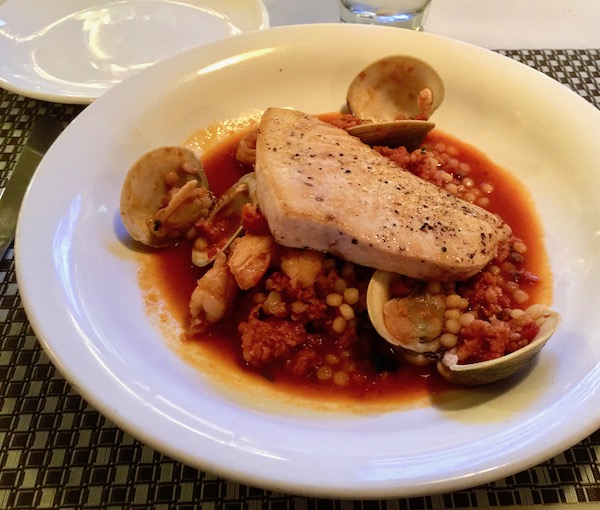 A large white plate with beans and rice and clams