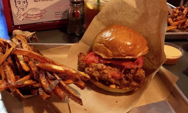 A fried chicken sandwich and fries on butcher paper