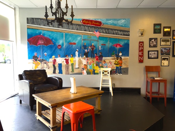 Waiting area of a restaurant with a mural of people