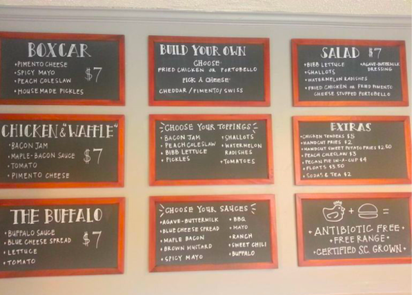 9 red framed chalkboards on a wall with menu items