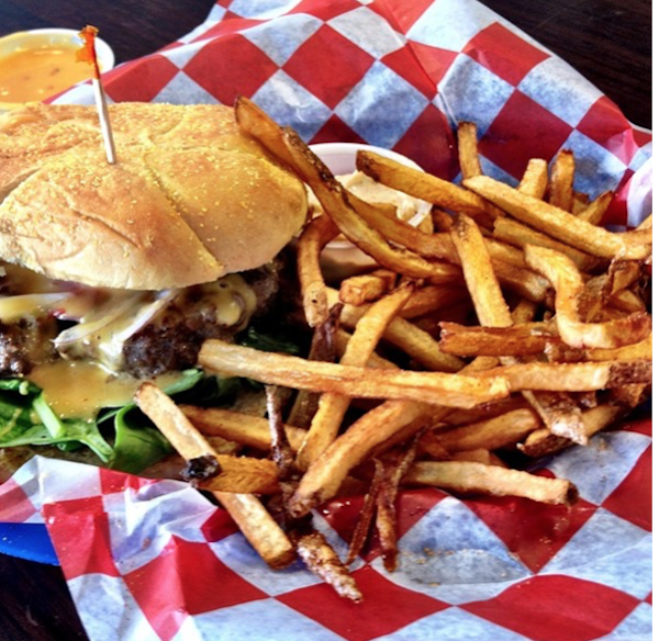 A Burger and fries on red and white checked deli paper