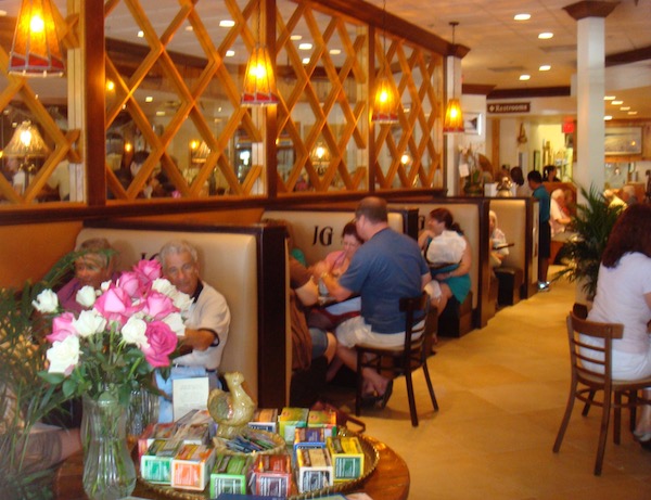 The inside of a restaurant dining room with booths filled with people