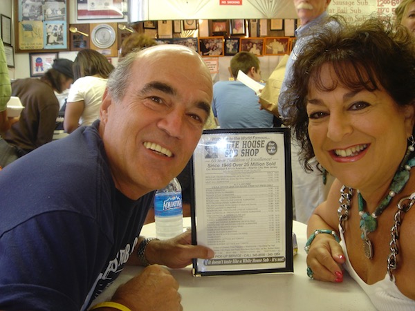 A man and a woman at a sub shop table with the menu between them