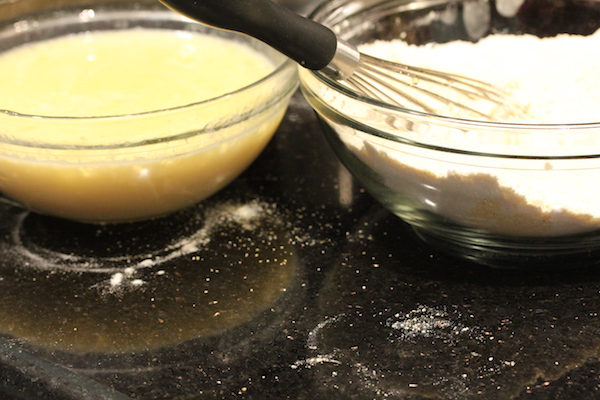 Two glass bowls filled with wet batter on left and dry ingredients on right.