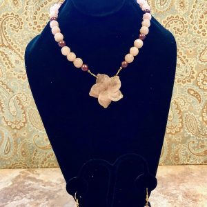Rose quartz and chocolate pearl necklace with carved rose quartz flower at center.