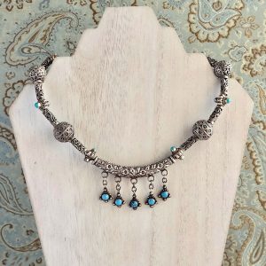 Oxidized Sterling Silver and Turquoise Necklace on a white washed display stand.