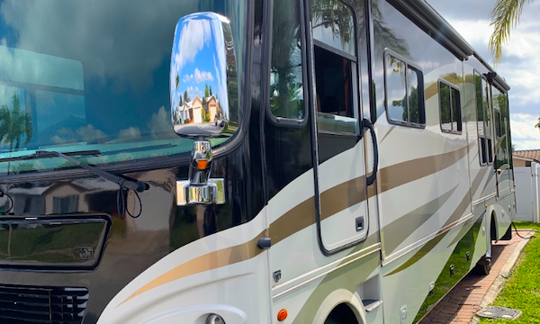 A black white and gold RV parked in a driveway