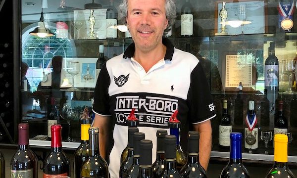 A man standing behind a row of wines at Balić Winery in Mays Landing, New Jersey.