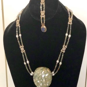 Swarovski Crystal, Pewter and Abalone Necklace and Bracelet on a black velvet display stand.