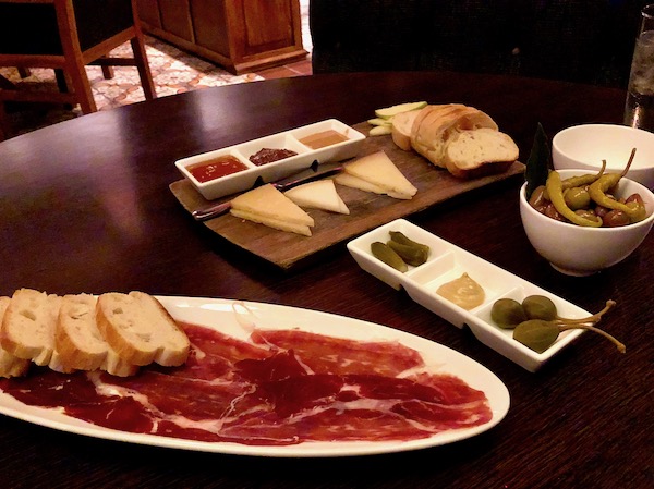 Chef José Garces' Amada Offers Tapas at its Best including this white oval plate of Jamon Iberico with slices of baguette, cheeses with mustards and a trio of condiments.