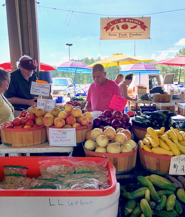 People looking at produce at the Raleigh Farmers Market.