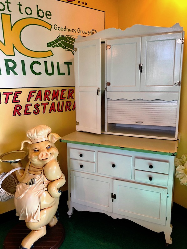 A pig chef sculpture and antique stove welcome you at the Farmers Market Restaurant at the Raleigh Farmers Market.