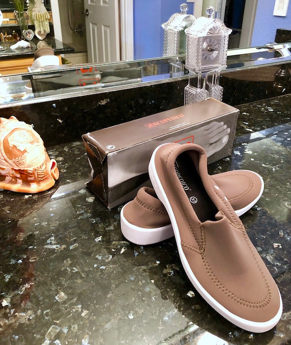 A pair of tan walking shoes on a black marble counter are part of my Gift Roundup for Mothers Day