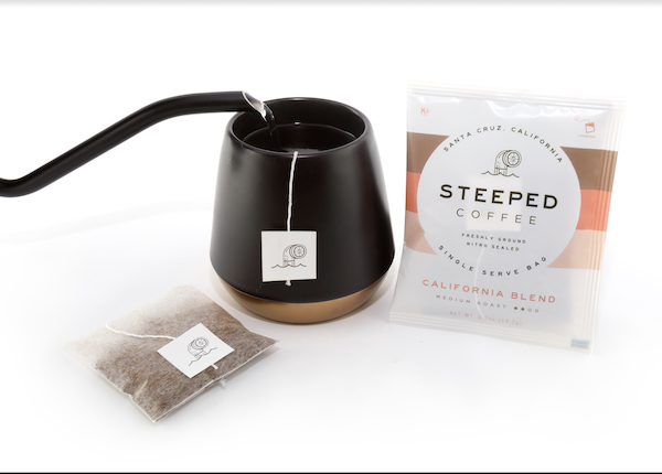 A black mug with a Steeped coffee bag being filled with hot water as part of my Gift Roundup for Mothers Day