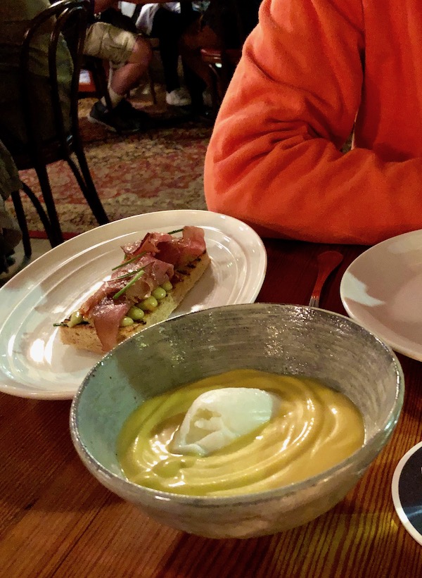 A bowl of thick yellow soup with a quenelle of buttermilk sorbet in the center at Bywater American Bistro in New Orleans