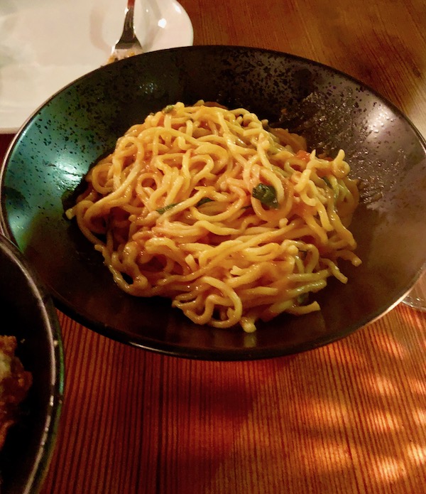 A matte black bowl filled with spaghetti in red sauce at Bywater American Bistro in New Orleans